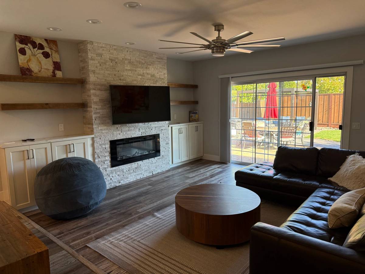 Living room before — warm-yellow cast, bean bag, blown-out patio.